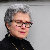 A person wearing glasses and looking at the camera Description generated with very high confidence
